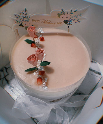 A pink mothers day cake decorated with candy roses