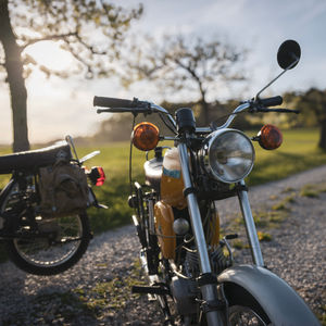 Zwei Retro-Simson-Mopeds auf einem Feldweg im warmen Abendlicht