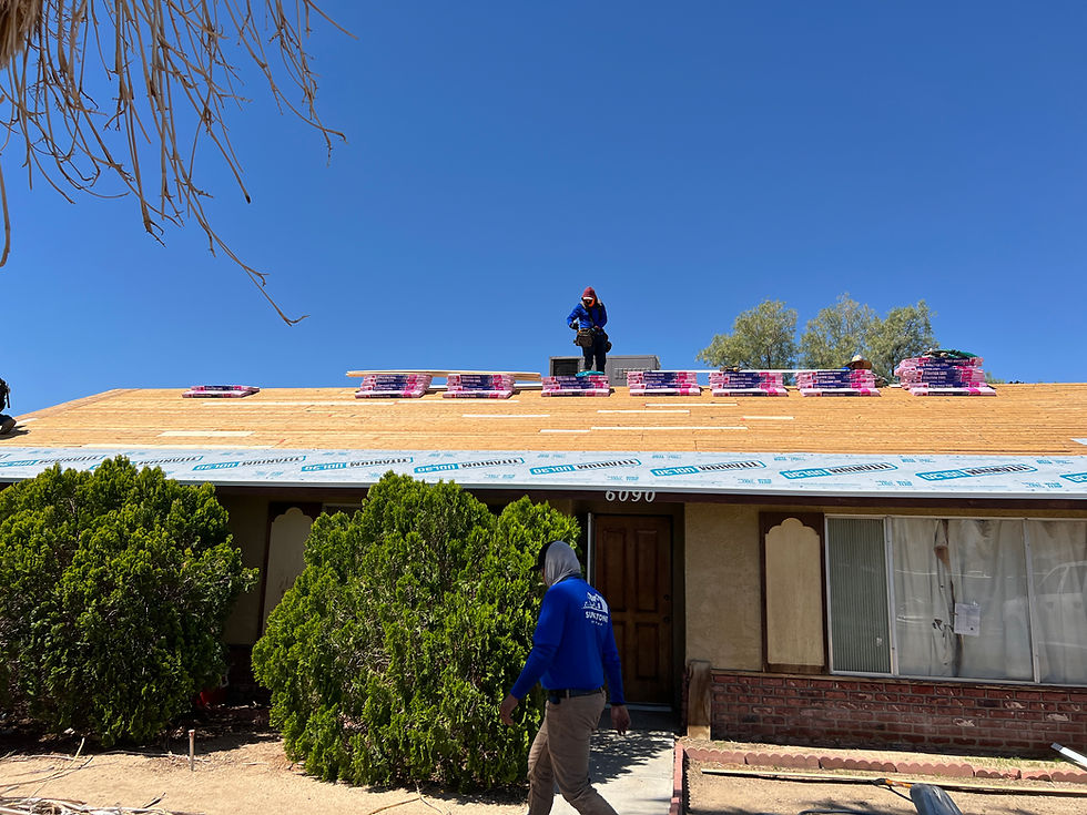 A house with workers installing a new plywood roof