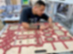 Die cut operator setting the scoring matrix on the cutting die before running sheets of custom product boxes