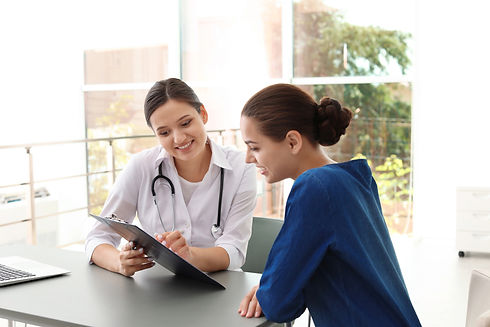 stock photo of healthcare professional in white jacket rewiving information on a clipboard with individiual
