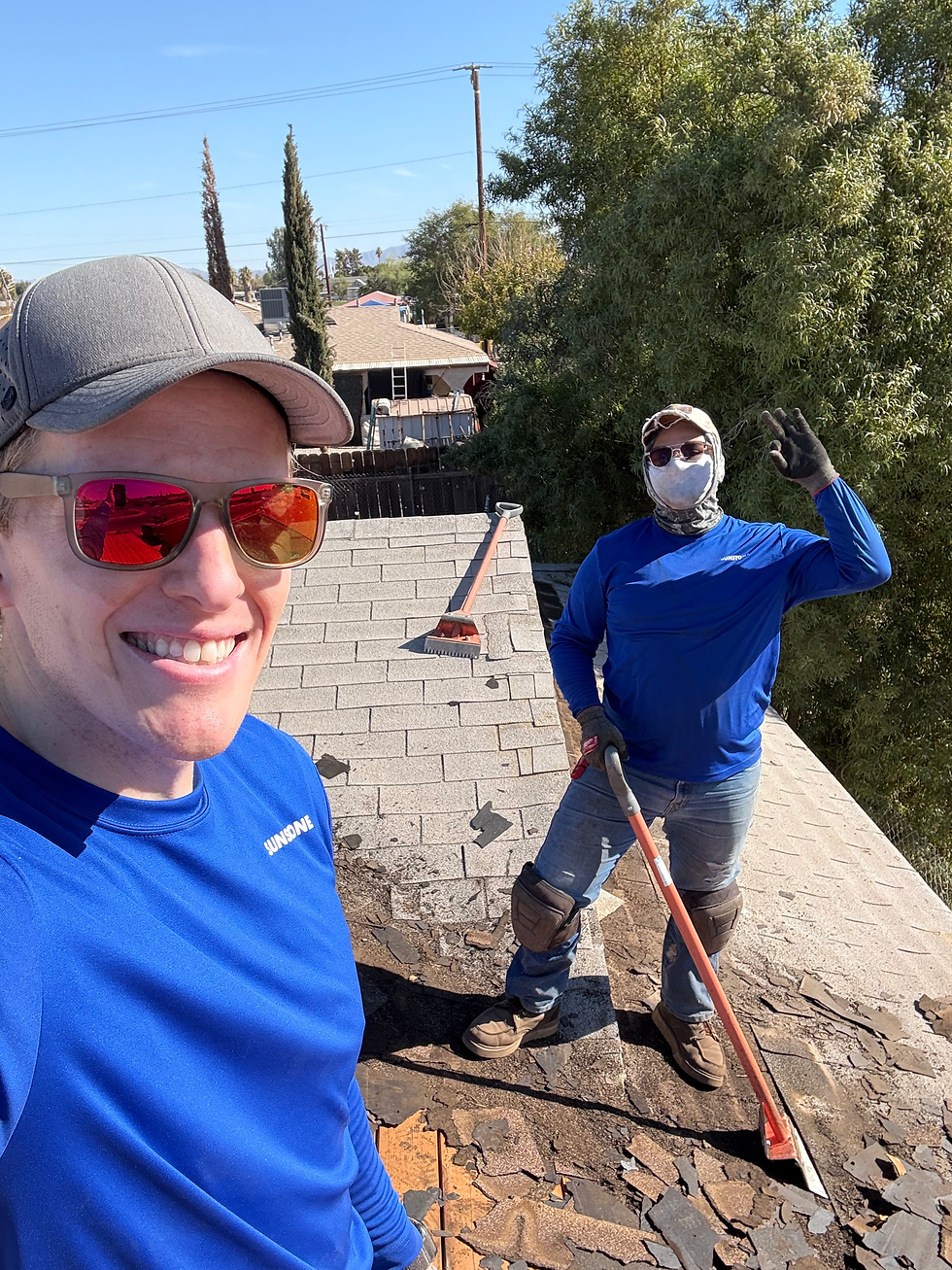 Workers with protective gear are on a rooftop performing roof cleaning