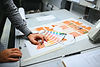 Auto lock bottom folding cartons being checked for Pantone color accuracy during print production