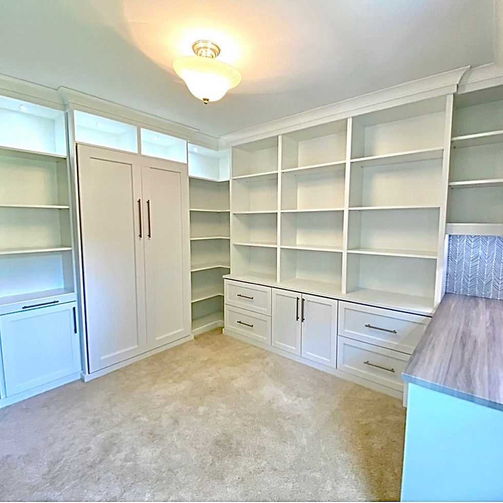 Custom white built-in storage with open shelving, cabinets, drawers, and a dedicated workspace.