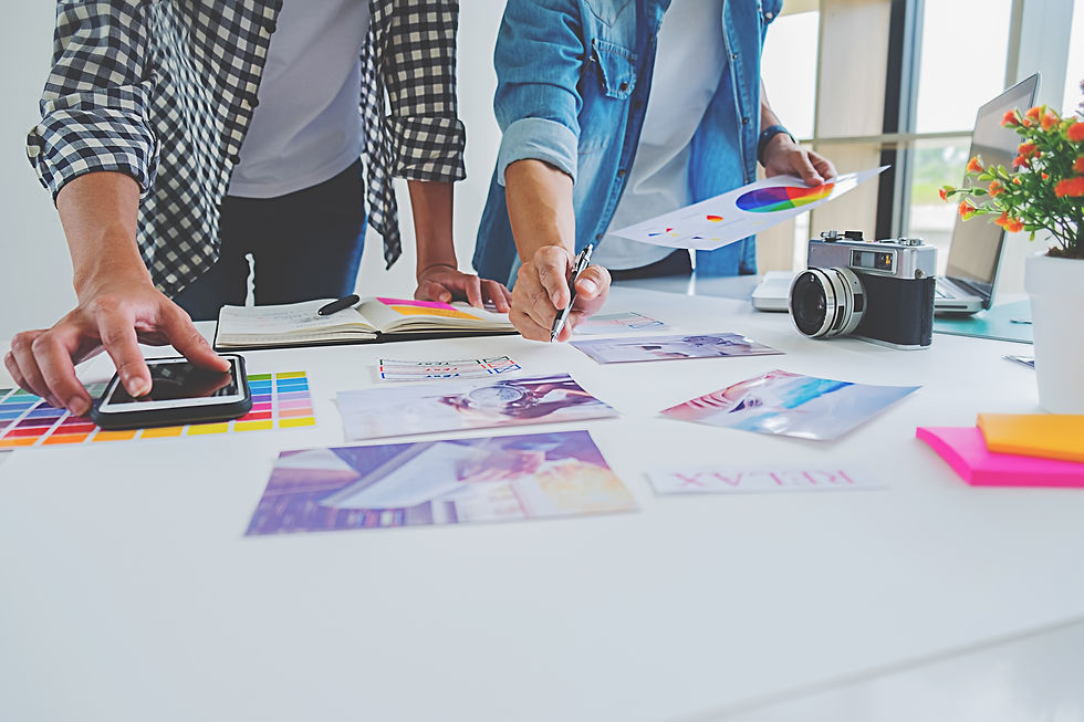 Two people checking print proofs against Pantone color samples for accuracy