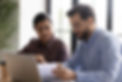 2 people looking at a paper