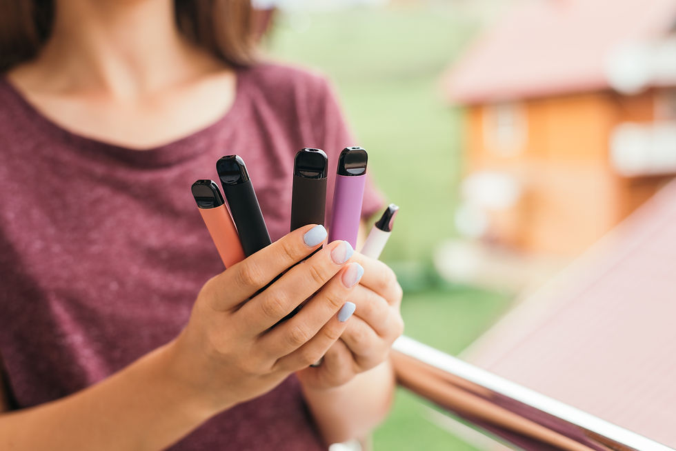 Teenager holding up vapes