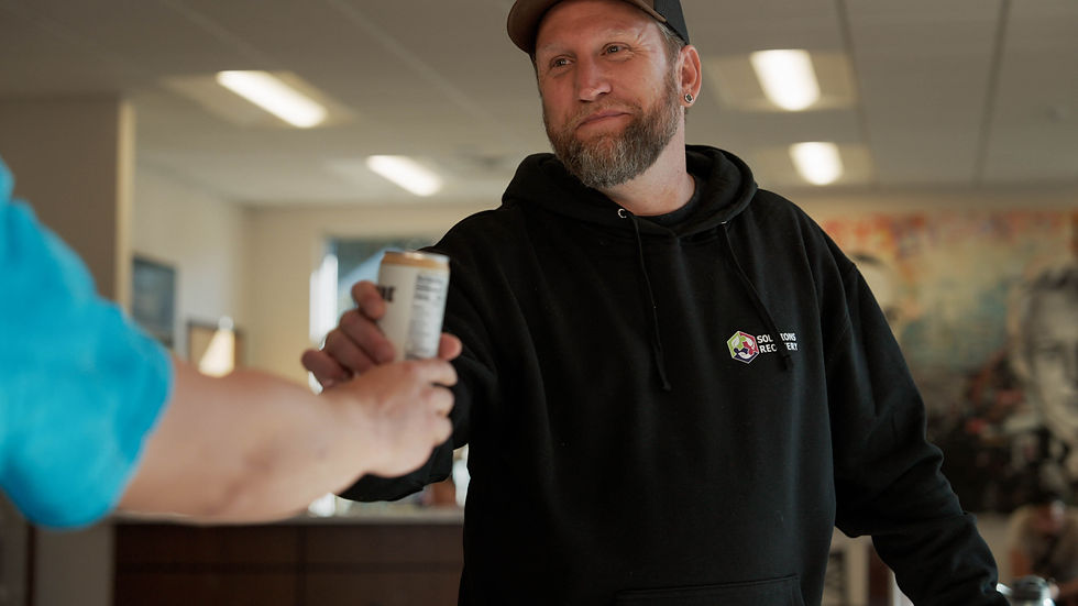 Man in recovery grabbing a drink at the counter.jpg