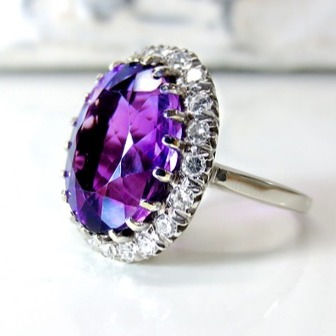 Antique style amethyst ring surrounded by small diamonds set in platinum