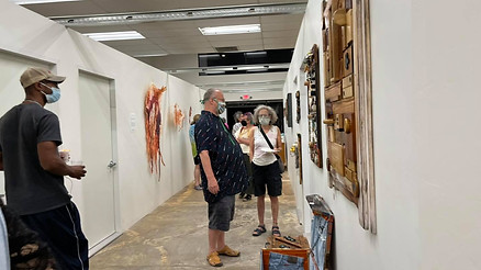 people viewing art in hallway on walls