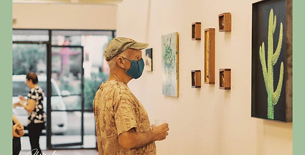 person viewing saguaro painting on wall