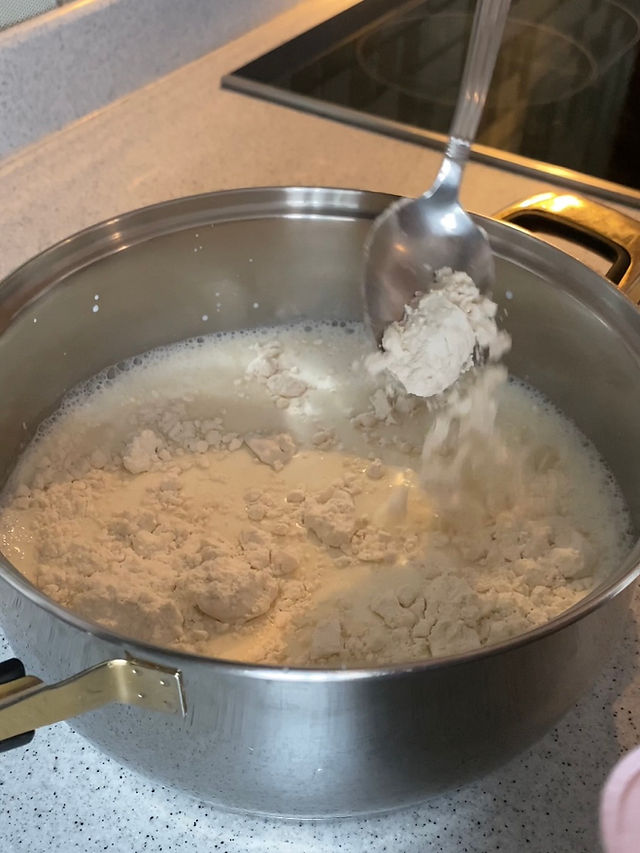 Flour added to the milk in the pan.