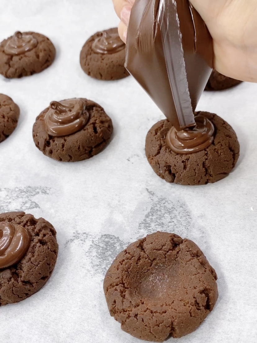 Squeezing cocolate cream on cookies