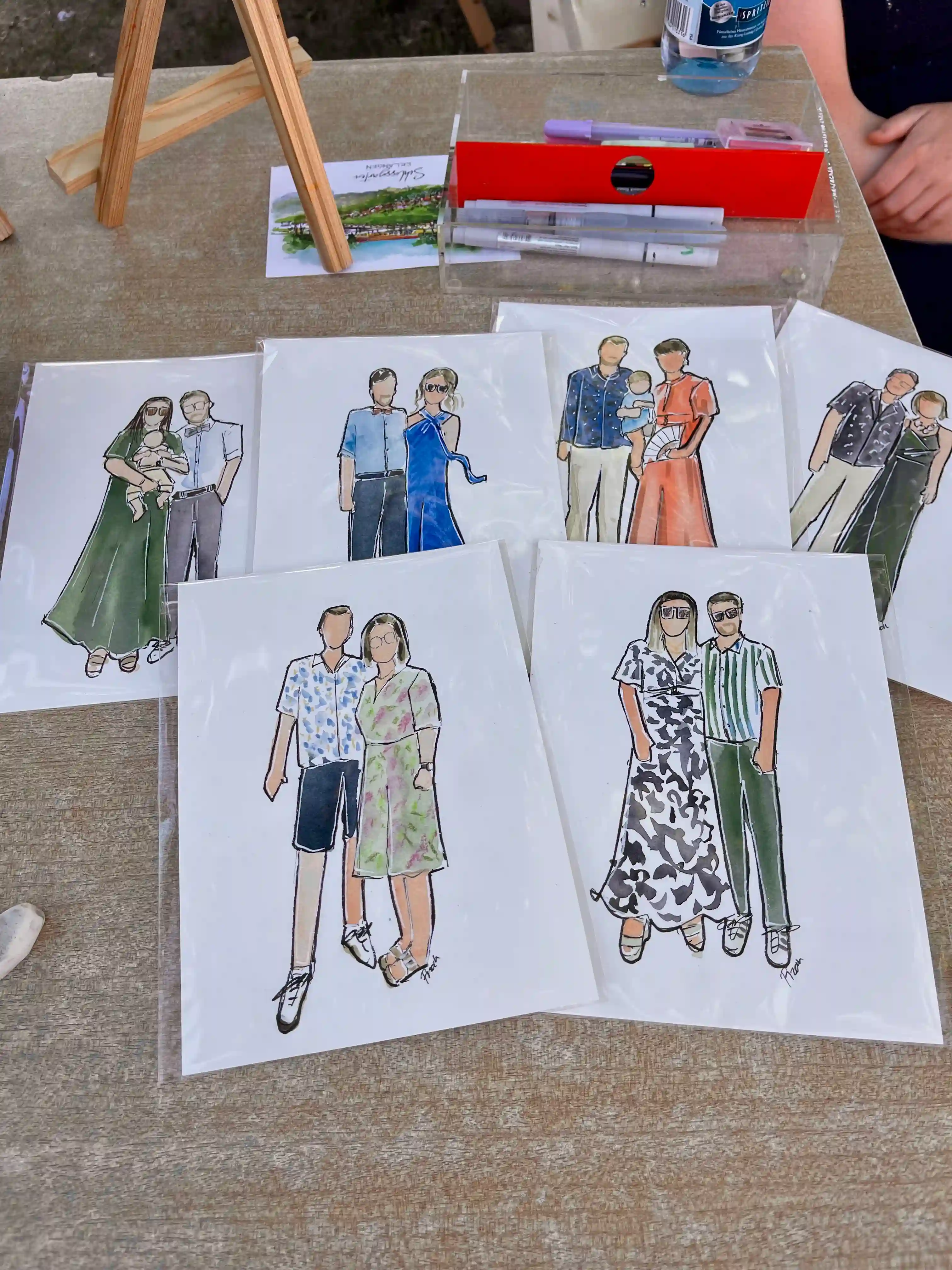 Sechs handgezeichnete Hochzeitsillustrationen von Gästen auf einem Tisch – Live Hochzeitszeichnerin Bayern 2025