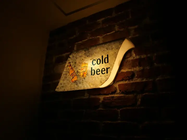 STEAK HOUSE 白砂の壁面。CAN'BRICKマンチェスター(MC-3)の赤茶色の凹凸とホワイト目地が際立ち、ヴィンテージの「cold beer」看板が映える
