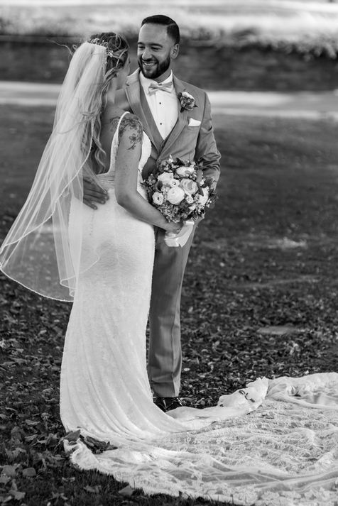 bride and groom embracing the moment in a field