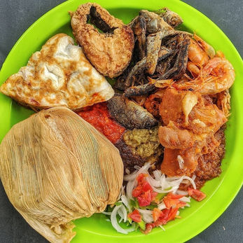 Ghana food called kinky served with fish, fried eggs, pepper stew and chopped vegetables