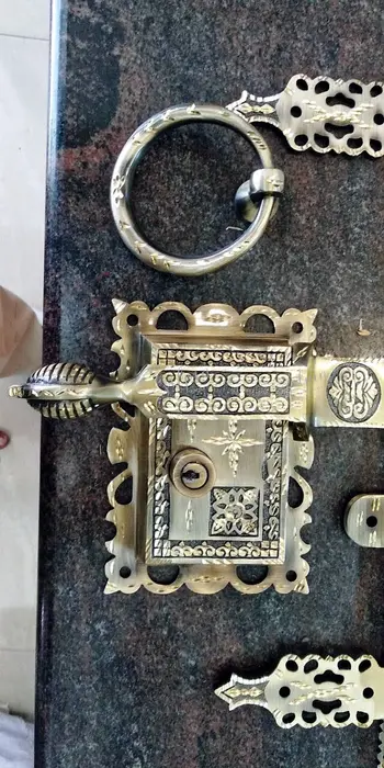 Kerala's antique lock, Manichitra Thazhu, featuring brass designs with Hindu Trisul, Christian dove, and Muslim Crescent symbols.