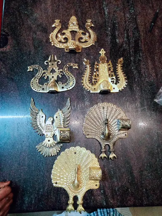 Various brass head designs of Manichitra Thazhu representing different religions: Hindu (Trisul head), Christian (dove head), and Muslim (Crescent head), with the Trisul head being the most popular.