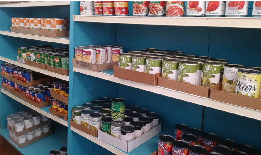 Shelves stocked with canned goods at The Corner Shoppe.