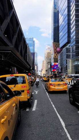 Scène urbaine animée avec taxis jaunes et architecture moderne