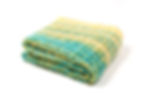 Folded view of Sprinkles travel blanket highlighting mixed turquoise hues