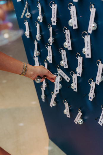 Seating chart met mini discoballen en naamlabels – originele wedding branding