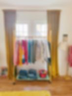 Colorful capsule wardrobe hanging on gold clothing rack