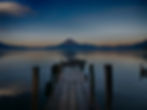 Muelle de madera en Lago de Atitlán con volcán al fondo, representando oportunidades laborales en un entorno natural en Guatemala