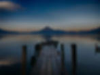 Muelle de madera en Lago de Atitlán con volcán al fondo, representando oportunidades laborales en un entorno natural en Guatemala
