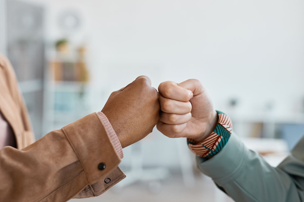close-up-two-ethnic-young-women-fist-bumping-office-setting-copy-space.jpg