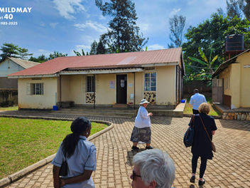 A group of people walking up the driveway of Joy Health Centre in Mbale