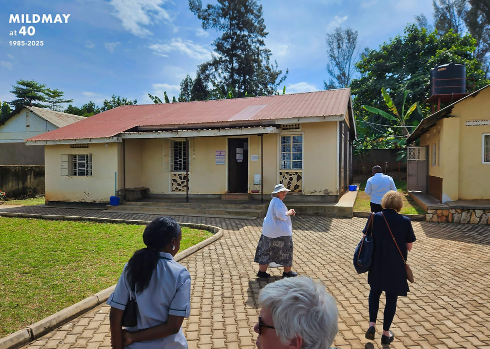 A group of people walking up the driveway of Joy Health Centre in Mbale