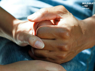 Close up of wo hands clasped in a care setting