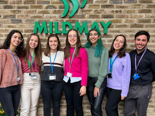 A group of students pose outside Mildmay Hospital by the Mildmay sign