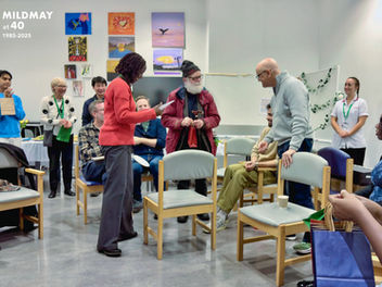 A group of people (staff and volunteers at Mildmay) gathered together in celebration