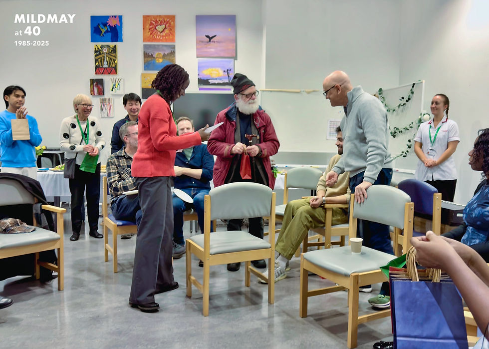 A group of people (staff and volunteers at Mildmay) gathered together in celebration