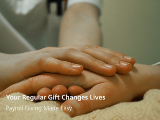 A medical professional clasps the hand of a bedbound patient