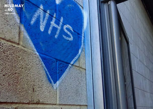 Graffiti of a blue heart containing the word NHS sprayed on a wall