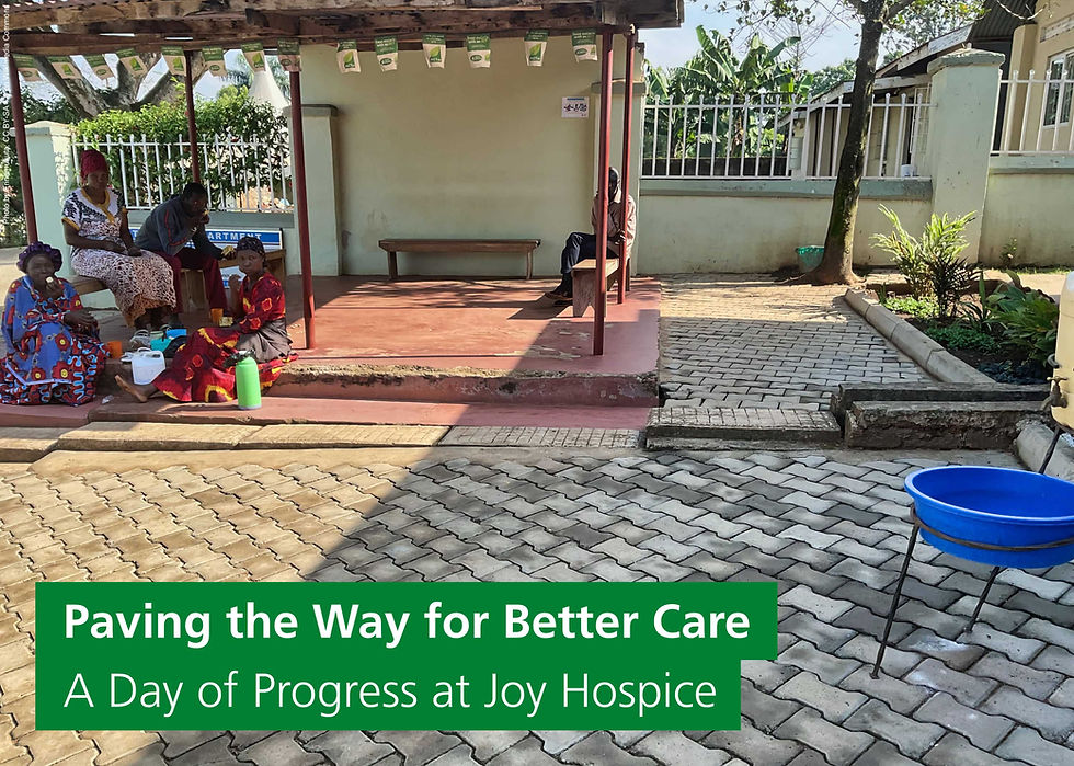 Women shelter from the sun under a canopy at Joy Health Centre, Mbale, Uganda. The banner reads: Paving the way for better care: A day of progress at Joy Hospice