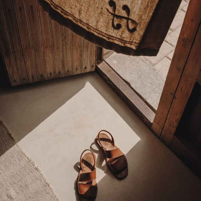 Brown leather sandals by doorway