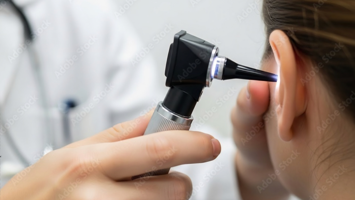 Doctor examining a patient's ear with an otoscope