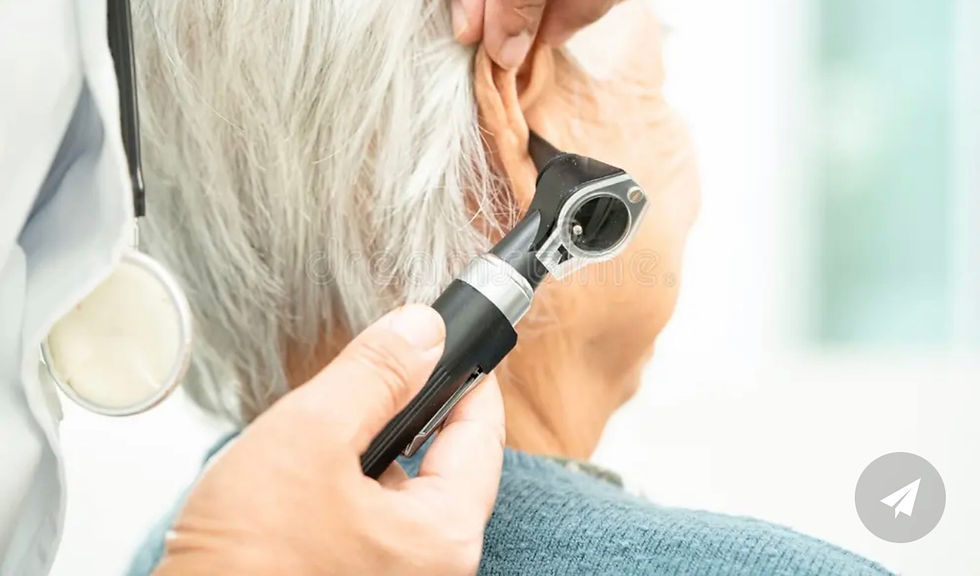 Doctor examining an elderly patient's ear with an otoscope
