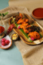 Deliciously prepared chicken dish with sauce and sides on a wooden tray
