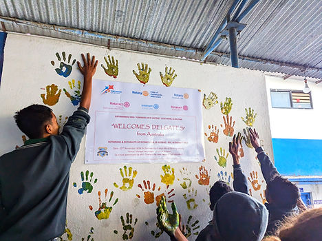 Students adding their hand prints to the wall