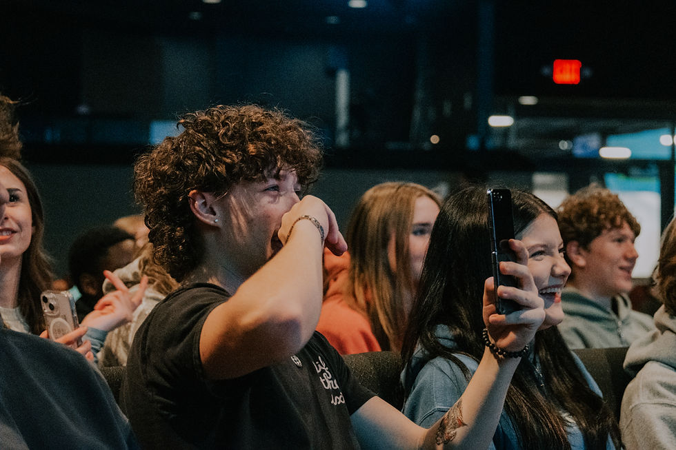 Youth audience laughing during a Christian comedy night at a church event