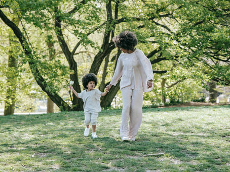 Parent and child walking together outdoors in a natural setting, supporting connection and healthy child development.
