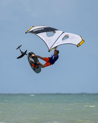 Wing foiler riding solo on a remote Brazilian beach during a Ventus trip