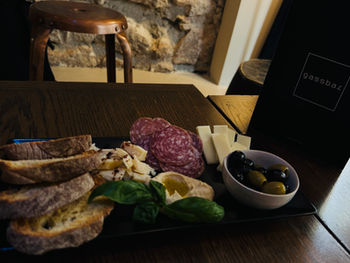 Gemischte Antipasti-Platte mit Brot, Käse, Oliven und Salami.