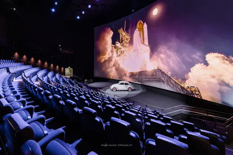 Modern theatre with blue seats and a large curved screen showing a space shuttle launch scene, representing cinema in switzerland.